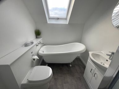 A bathroom with a bathtub toilet sink and skylight at The Little Beehive in Abberley