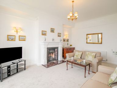 A living room with sofas a coffee table a fireplace and a television at Weymouth Bay Apartment A in Weymouth