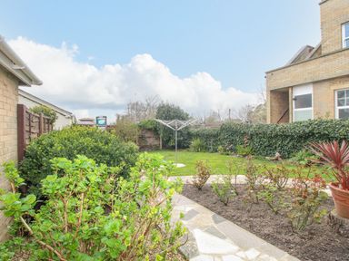 A garden with plants and a rotary clothesline at Weymouth Bay Apartment A in Weymouth