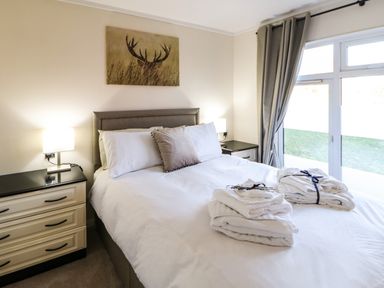 A bedroom with a bed a bedside cabinet lamps and towels on the bed at Badgers Retreat in Tunstall near Hipswell