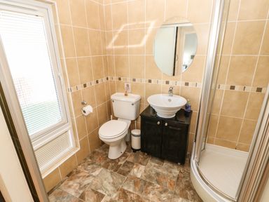 A bathroom with a toilet sink mirror and shower at Badgers Retreat in Tunstall near Hipswell