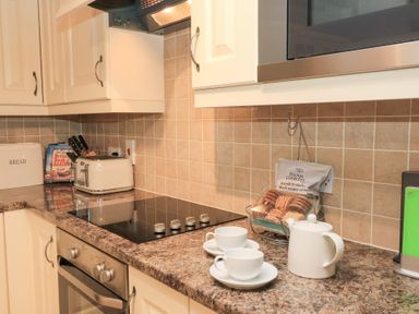 A kitchen with a teapot and cups on the counter at Butlers Cottage in Burford