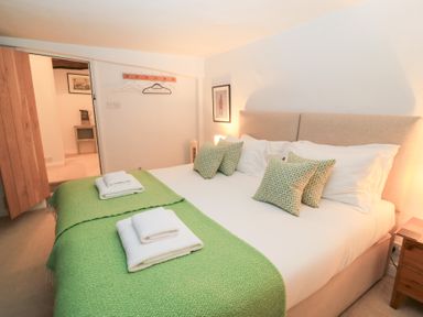 A bedroom with a bed and bedside table at Butlers Cottage Burford