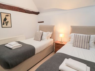 A bedroom with two beds and a lamp at Butlers Cottage in Burford