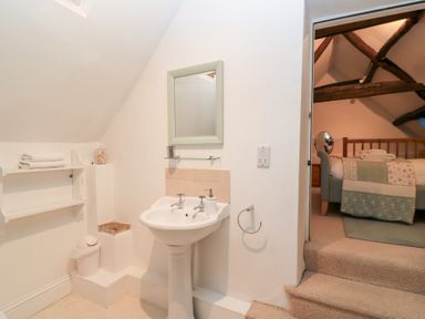 A bathroom with a sink and mirror at Butlers Cottage in Burford