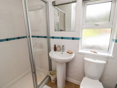 A bathroom with a shower cubicle sink mirror toilet and frosted window at Hillside View in Alnwick