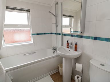 A bathroom with a bathtub shower sink toilet and window at Hillside View in Alnwick