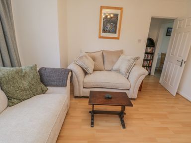 A living room with two beige sofas a small wooden coffee table and a framed picture on the wall at Sea Change Newholm near Whitby