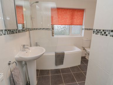 A bathroom with a sink a bathtub with a shower and a toilet at Sea Change in Newholm near Whitby