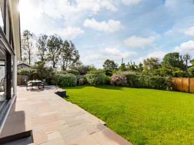 A garden with a grassy lawn patio with outdoor dining table and chairs at The Garden House in Rock