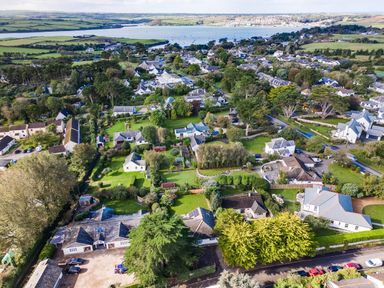 An aerial view of a residential area with houses and green gardens near a river at The Garden House in Rock