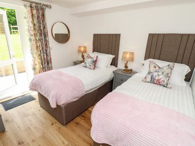 A bedroom with two single beds bedside tables lamps and a wall mirror at Amarone in Seaview