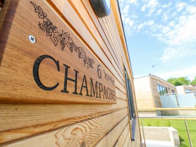 A wooden nameplate with the number 6 and the word Champagne on the exterior wall of a wooden building at Champagne in Seaview
