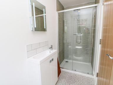 A bathroom with a sink vanity and a glass shower enclosure at Barolo in Seaview