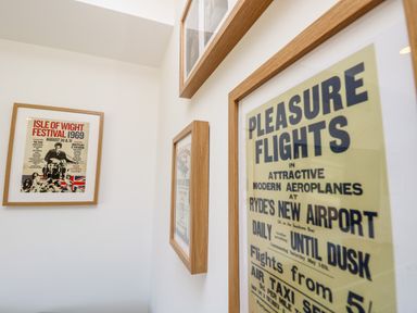 Framed vintage posters on a white wall at Cava in Seaview