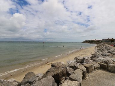 A beach with rocks along the shore and people in the water at Chianti in Seaview