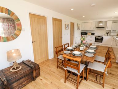 A kitchen and dining area with a wooden table set with plates and glasses at Chianti in Seaview