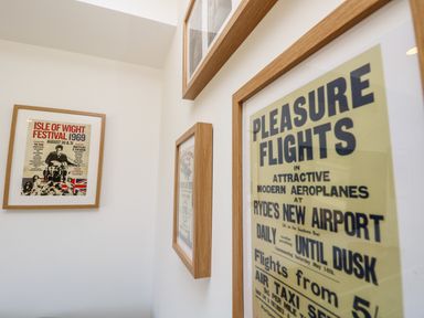 A corner of a room with framed vintage posters on white walls at Chianti in Seaview