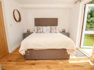 A bedroom with a bed between two nightstands and a round mirror on the wall at Chianti in Seaview
