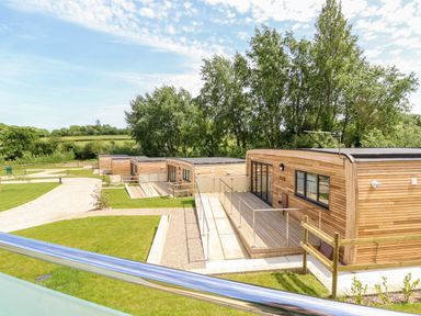 Modern wooden lodges with walkways surrounded by grass and trees at Chianti in Seaview