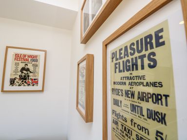 Framed vintage posters on white walls in a room at Claret in Seaview