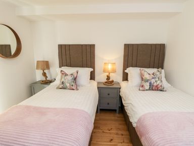 A bedroom with two single beds bedside tables and lamps at Claret in Seaview
