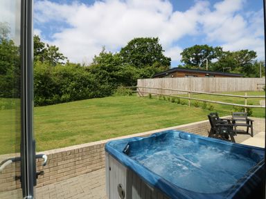 A garden with a hot tub patio furniture and a wooden fence at Claret in Seaview