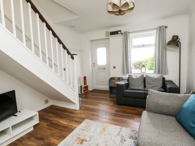 A living room with two sofas a side table and a staircase at Little Tern Brewers Quay Harbour