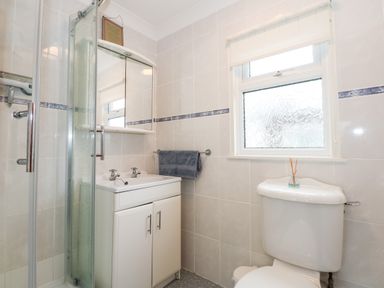 A bathroom with a shower enclosure sink cabinet mirror towel rail and toilet at Chalet 12 in Hemsby