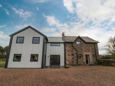 A house with a modern extension and stone facade with gravel driveway at Shepherds House in Lowick