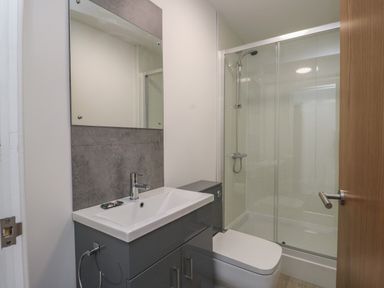 A bathroom with a sink cabinet toilet and a glass shower enclosure at Llety Pen Deitsh 1 in Caernarfon