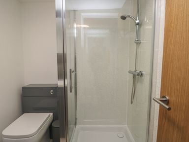 A bathroom with a shower enclosure and a toilet next to it at Llety Pen Deitsh 2 in Caernarfon