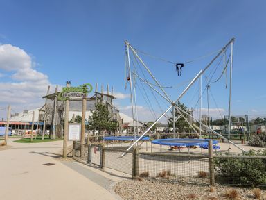 An outdoor trampoline area with bungee trampolines and a wooden play structure at 171 Snowdonia View in Chwilog