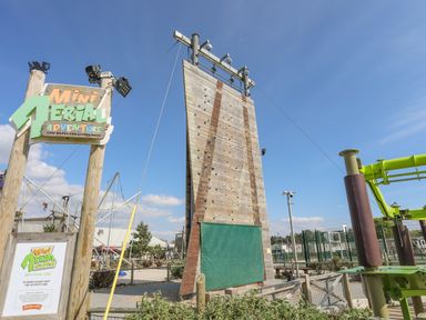 An outdoor climbing wall and a sign for Mini Aerial Adventure at Dragon Lakes