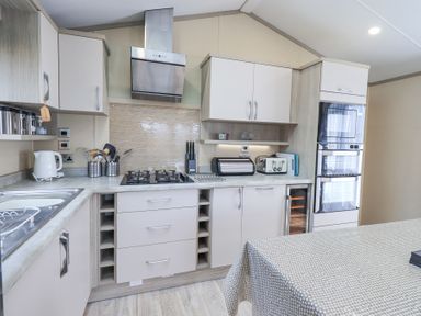 A kitchen with a gas stove oven microwave toaster kettle and countertop appliances at Windermere View in Pony Meadow 37 White Cross Bay near Windermere