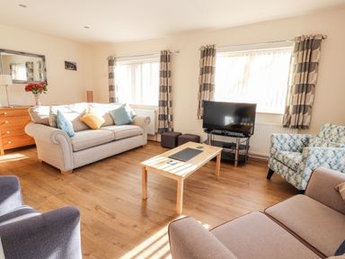 A living room with sofas a television and a wooden coffee table at Awel Y Berwyn in Llangynog