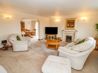 A living room with sofas a coffee table a television and a fireplace at Corner House in Cinderford