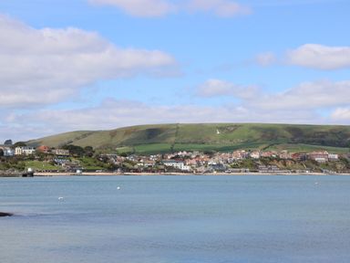 A coastal view with buildings and hills at Stag Cottage in Lytchett Matravers