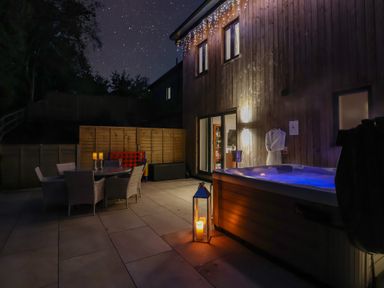 A garden with a hot tub and outdoor dining area at Stag Cottage in Lytchett Matravers