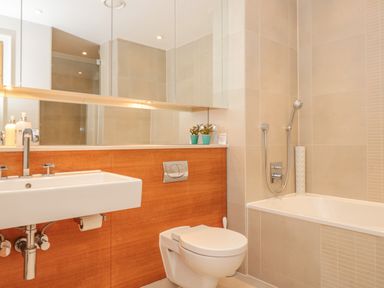 A bathroom with a sink toilet bathtub and mirror at 15 Dart Marina in Dartmouth