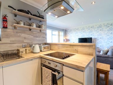 A kitchen with stove oven kettle toaster pots pans and a fire extinguisher at Bungalow 14 in Corton