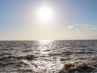 A large body of water with waves and the sun shining above at Apple Tree House in Hunstanton
