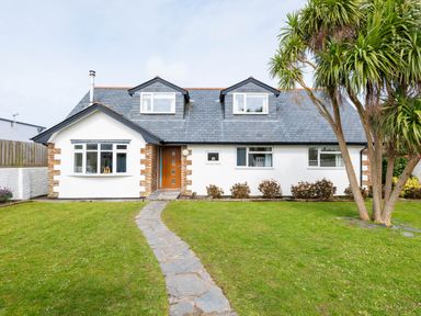 A house with a stone path leading to a wooden door and trees on the lawn at Silverdale in Rock