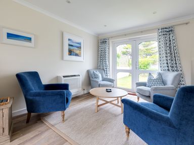 A sitting room with blue and grey armchairs and a round wooden coffee table at Silverdale in Rock