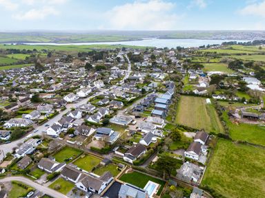 Aerial view of a residential area with houses roads and green fields near water at Silverdale in Rock