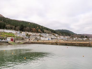 A harbor with boats docked near houses on a hillside at Rocklea Seaside Cottage in Newcastle County Down