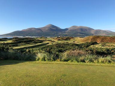 A grassy landscape with hills and mountains under a clear sky at Rocklea Seaside Cottage in Newcastle County Down