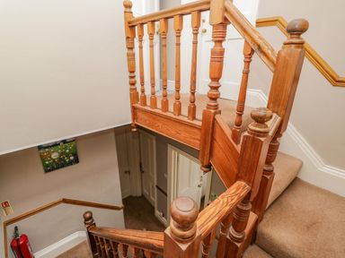 A stairwell with wooden banisters and beige carpeting at Hollywood in Windermere