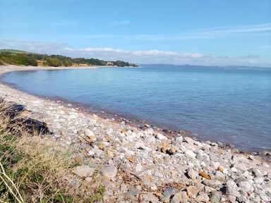 A beach with pebbles and water at Seashore Shepherds Hut @ Moat Farm Aldingham near Ulverston