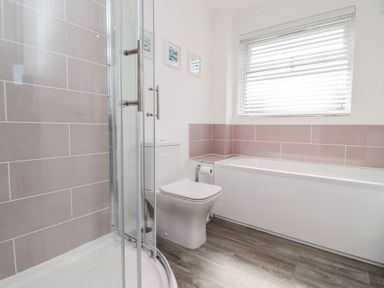 A bathroom with a shower enclosure toilet bathtub and window blinds at 3 Granbrook Lane in Mickleton Gloucestershire